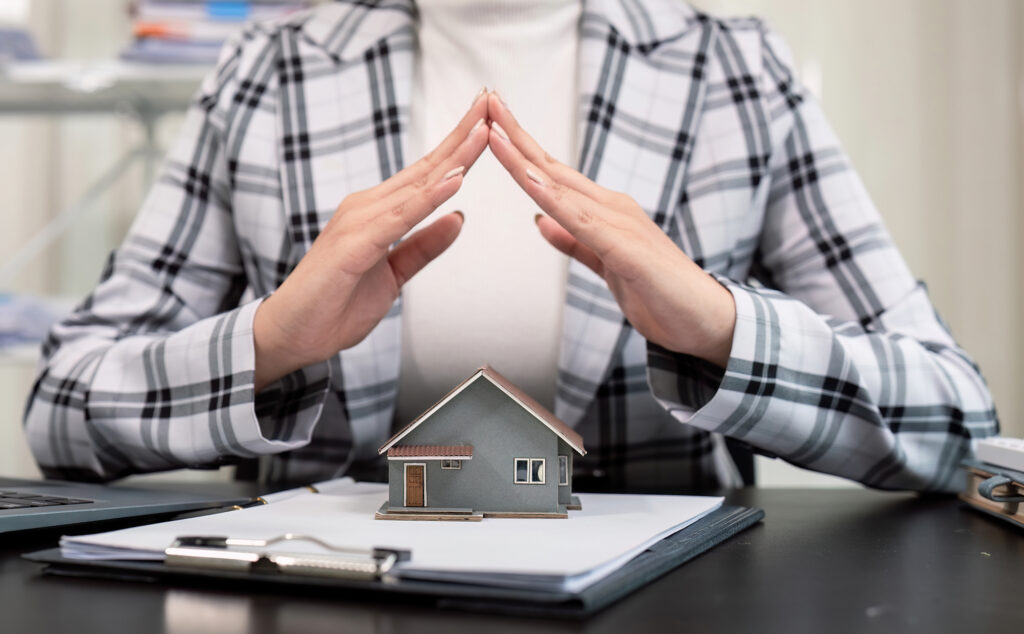 Des mains au-dessus d'une petite maison
