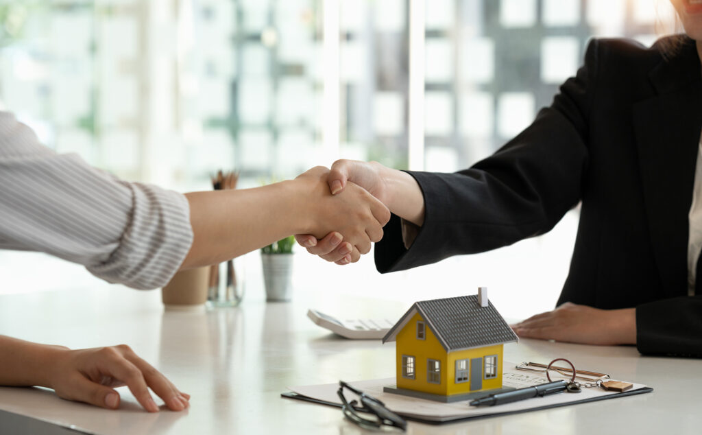 Deux personnes se serrant la main après la signature d'un contrat immobilier